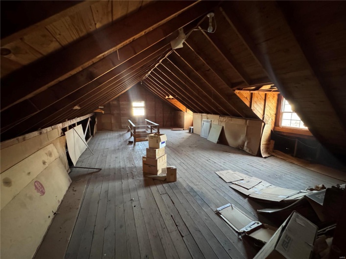 Unfinished attic with an upstairs landing