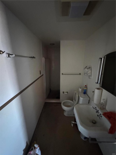 Full bathroom featuring a stall shower and toilet