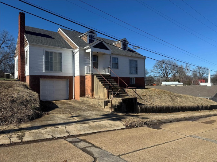 View of front of property with a shingled roof, central AC, driveway, and an attached garage