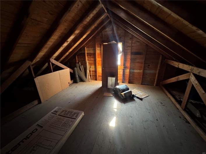 Unfinished attic featuring an upstairs landing