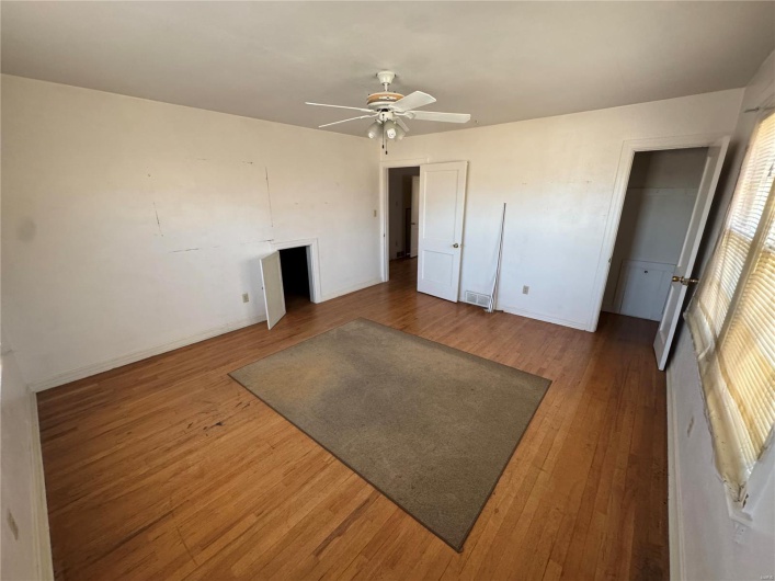 Bedroom with ceiling fan, wood-type flooring, visible vents, and baseboards