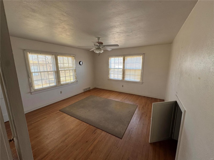 Spare room featuring a textured ceiling, wood finished floors, and visible vents