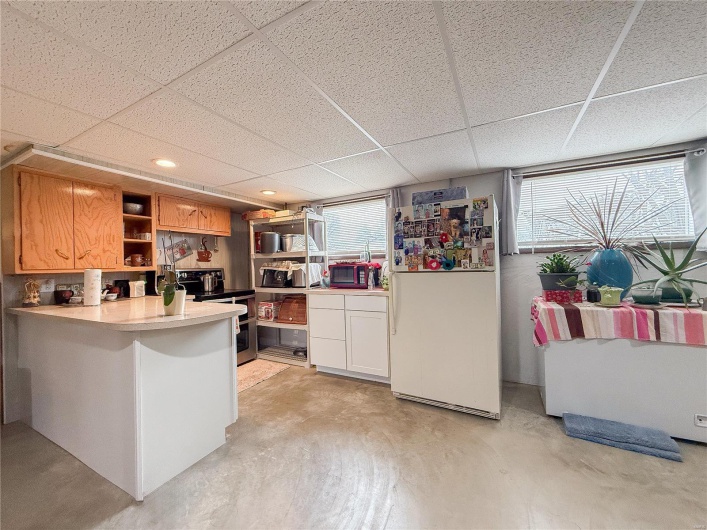 Kitchen featuring stainless steel range with electric stovetop, plenty of natural light, open shelves, and freestanding refrigerator