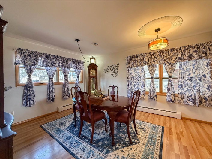 Dining space featuring a baseboard heating unit and wood finished floors