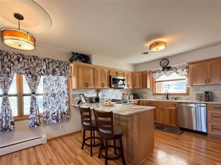 Kitchen featuring light wood-type flooring, stainless steel appliances, a sink, and light countertops