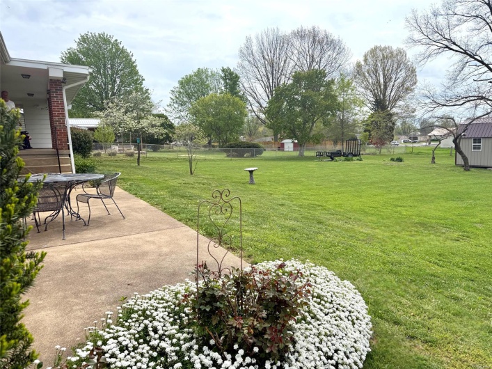 View of yard with fence, outdoor dining area, and a patio area