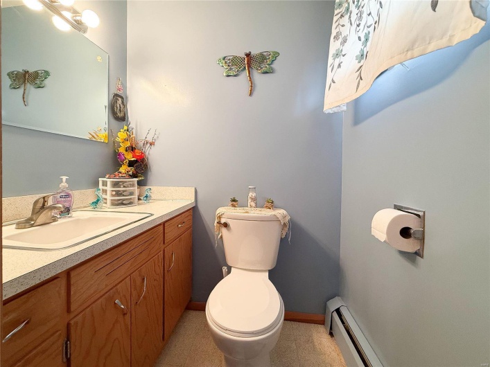 Bathroom with a baseboard radiator, baseboards, vanity, and toilet