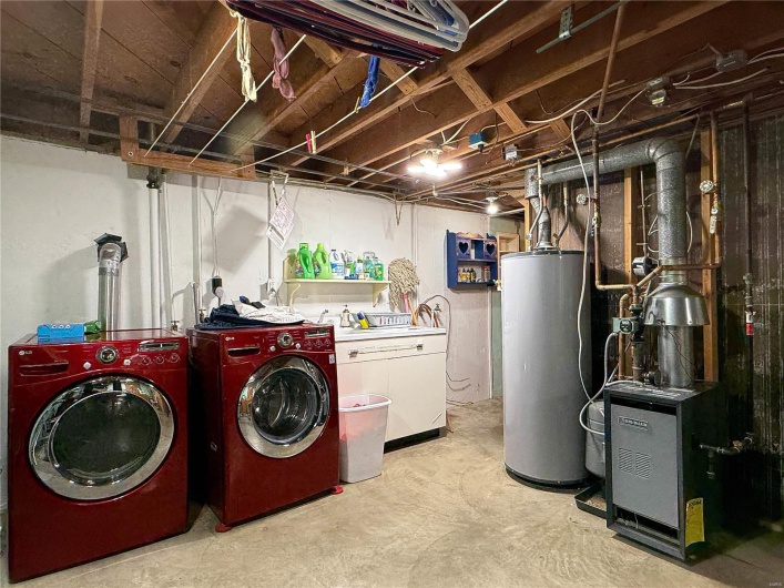 Clothes washing area with gas water heater, a heating unit, washer and clothes dryer, and laundry area
