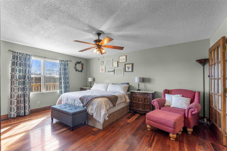 Bedroom featuring a textured ceiling, dark wood finished floors, and a ceiling fan