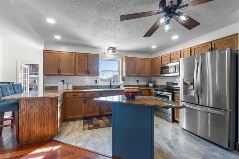 Kitchen with a sink, a kitchen island, appliances with stainless steel finishes, and a breakfast bar area