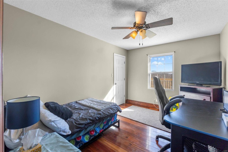 Bedroom with dark wood-style flooring, ceiling fan, a textured ceiling, and baseboards