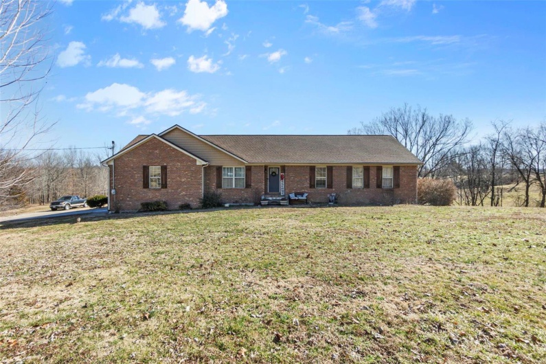 Single story home with brick siding and a front lawn