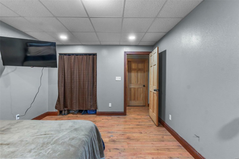 Bedroom with recessed lighting, wood finished floors, a paneled ceiling, and baseboards