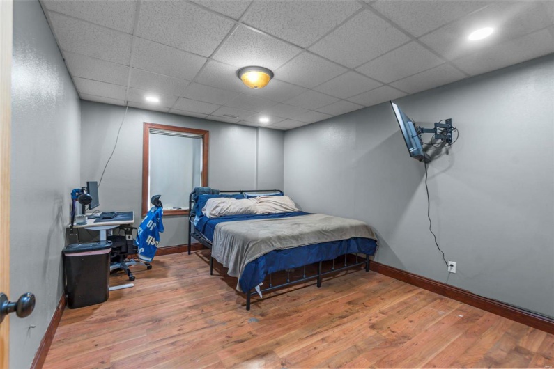 Bedroom featuring baseboards, a drop ceiling, wood finished floors, and recessed lighting