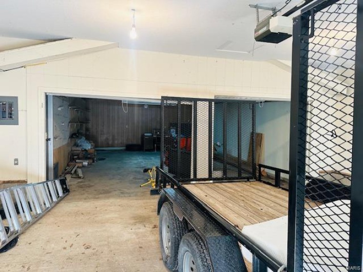 Garage featuring a garage door opener and electric panel