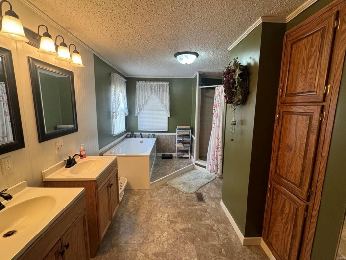 Bathroom with a textured ceiling, a stall shower, a sink, and a bath