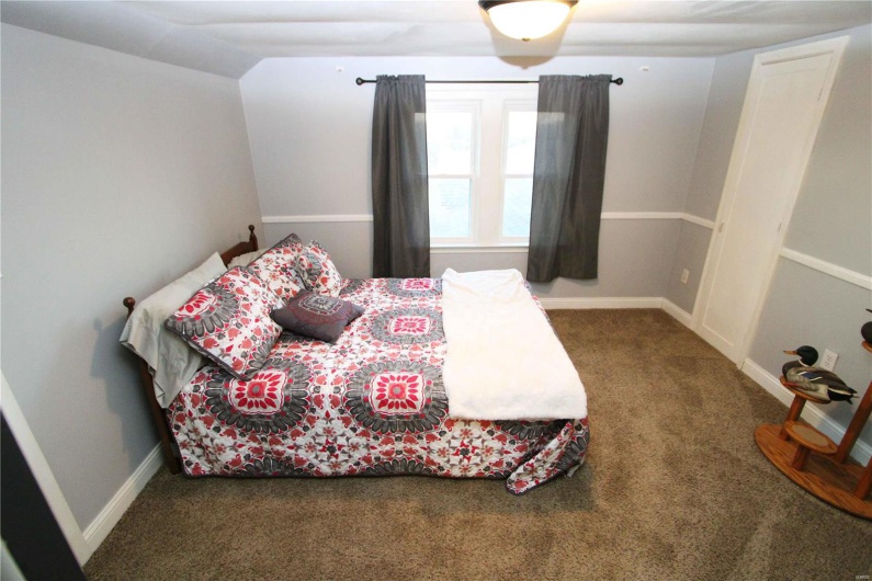 Bedroom featuring lofted ceiling, baseboards, and carpet flooring