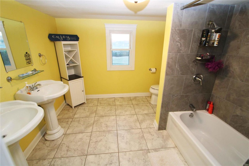 Bathroom featuring toilet, shower / bath combination, and baseboards