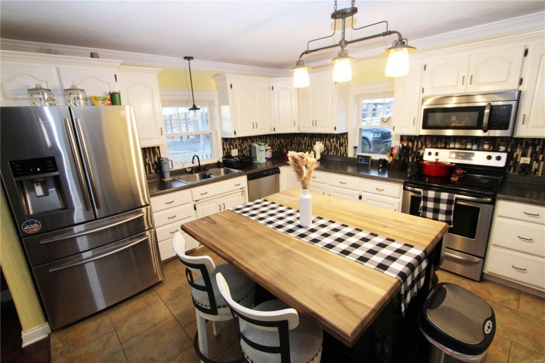 Kitchen featuring plenty of natural light, decorative backsplash, stainless steel appliances, and a sink