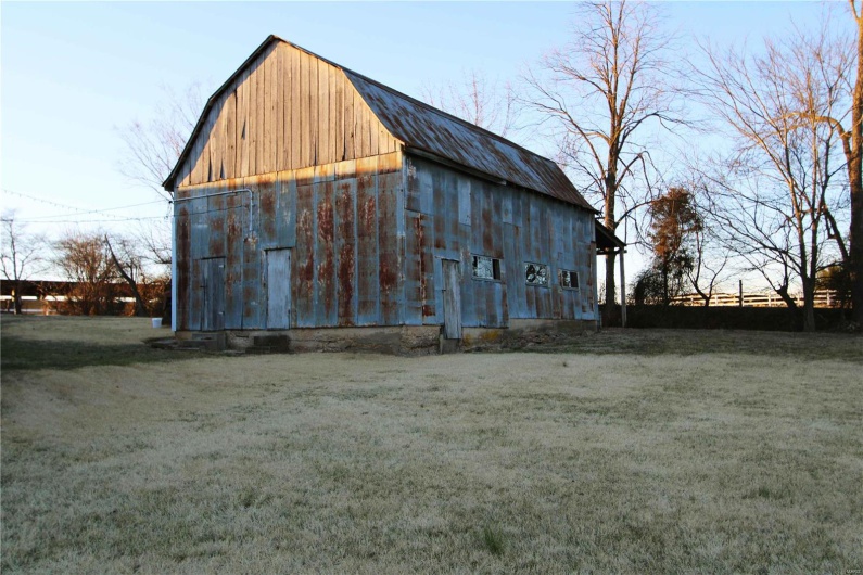View of barn featuring a lawn