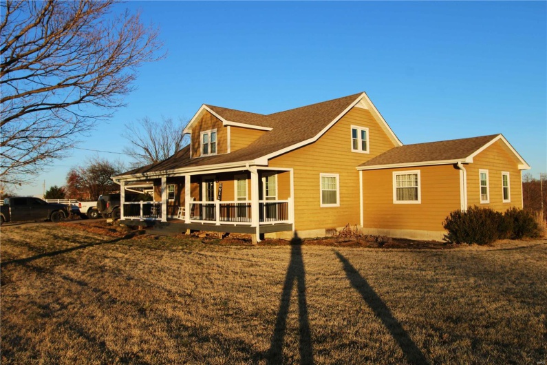 Back of property featuring roof with shingles and a yard