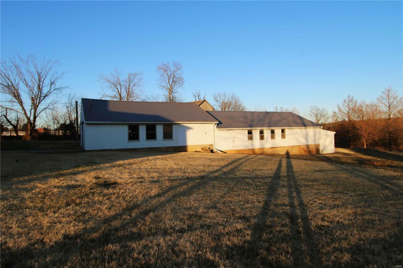 View of front facade featuring metal roof and a front lawn