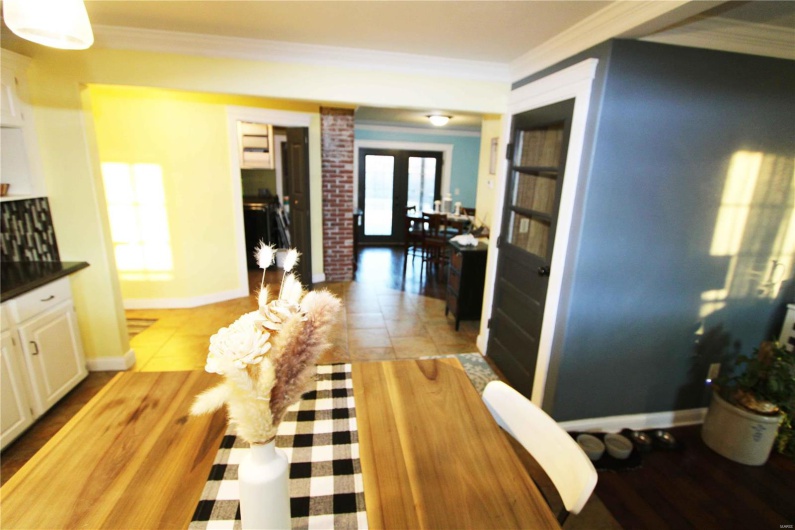 Kitchen featuring baseboards, ornamental molding, dark countertops, and white cabinets