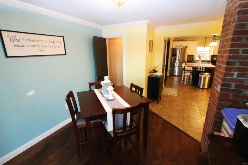Dining room with dark wood-style floors, ornamental molding, and baseboards