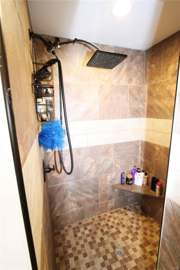 Full bath featuring a tile shower
