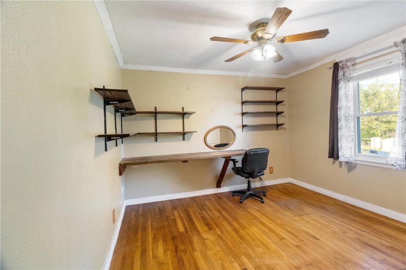 Office featuring crown molding, baseboards, a ceiling fan, and wood finished floors