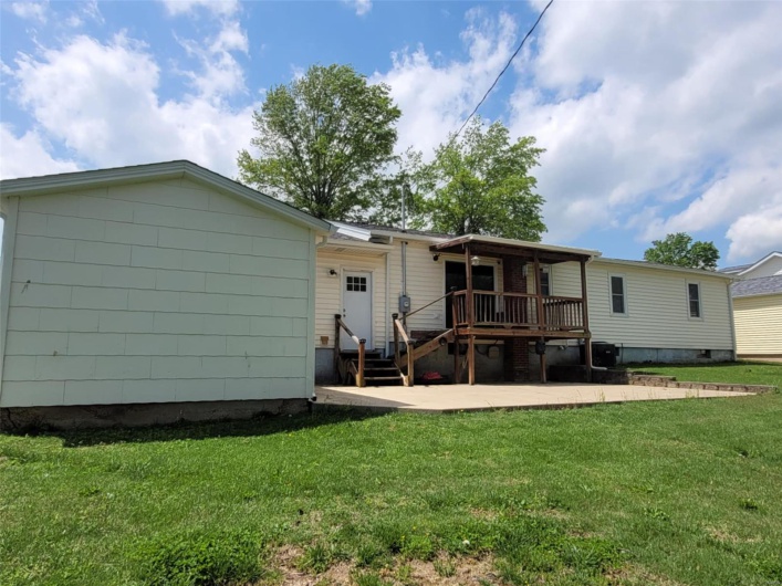 Back of house with a yard and a patio area