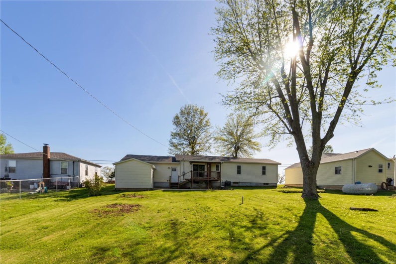 Back of house with a lawn and fence