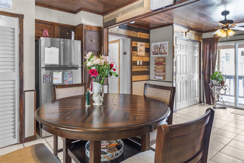 Dining room with light tile patterned floors, wood ceiling, and a ceiling fan
