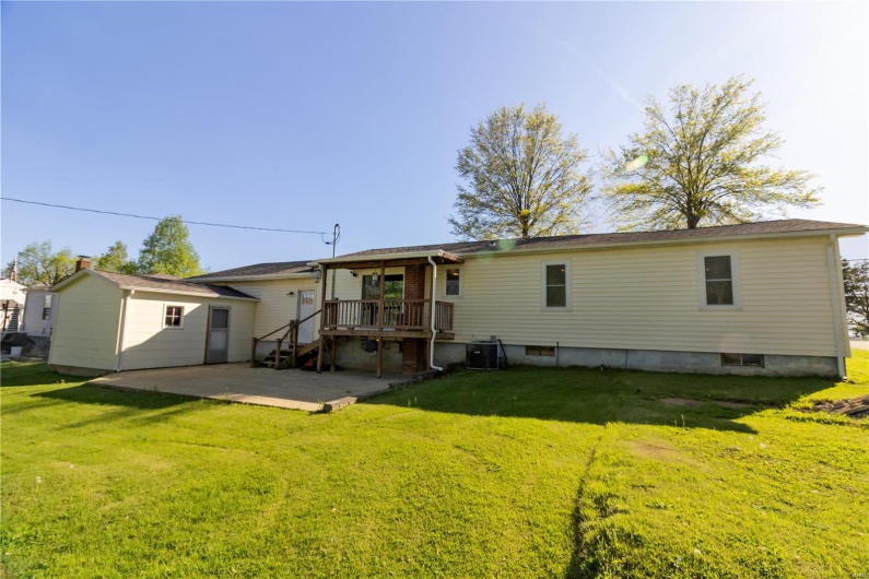 Back of house featuring a deck, a patio area, a yard, and central AC