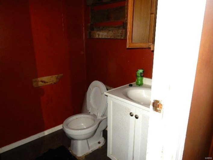 Bathroom featuring toilet, baseboards, and vanity