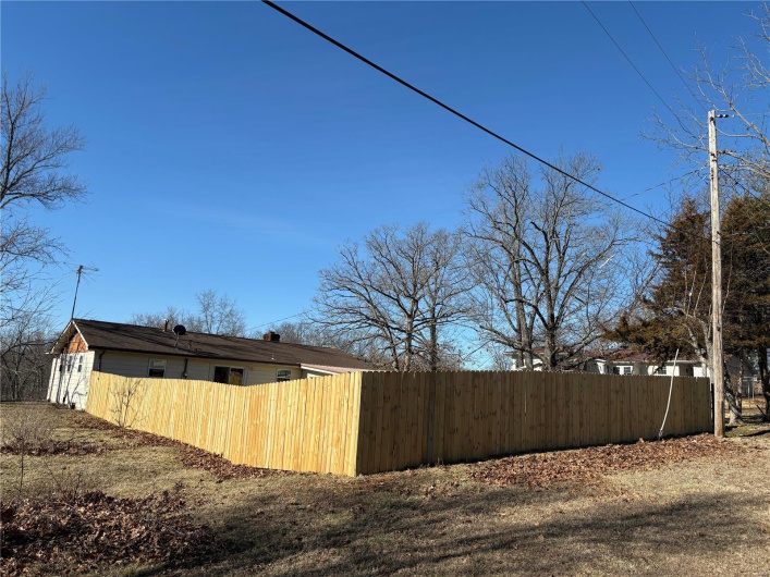 View of home's exterior with fence and a chimney