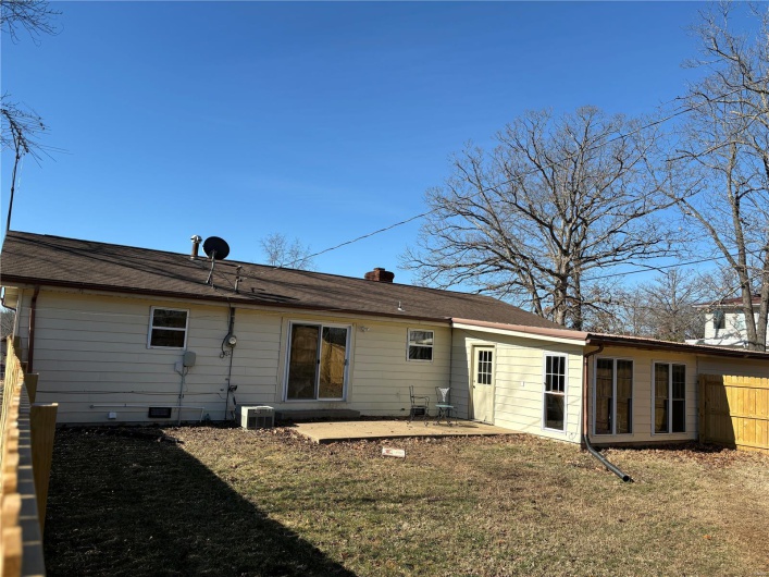 Back of house with a lawn, a patio, crawl space, fence, and central AC