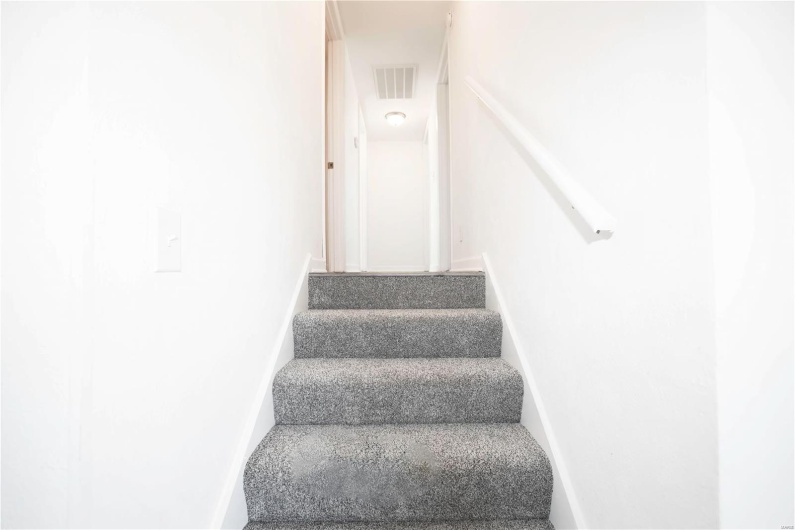 Stairs with visible vents and baseboards