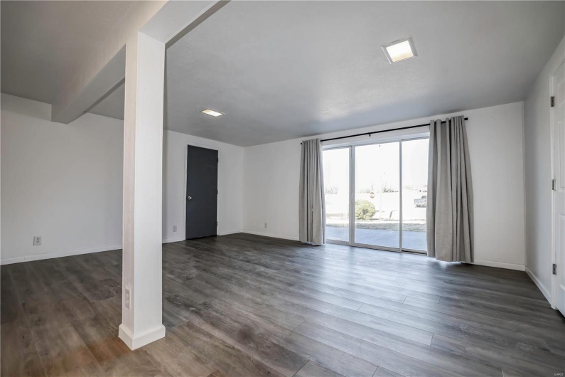 Empty room featuring dark wood-type flooring and baseboards