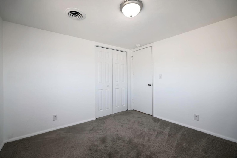 Unfurnished bedroom with a closet, carpet flooring, visible vents, and baseboards