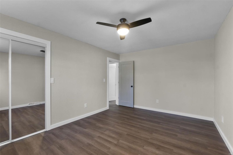 Unfurnished bedroom featuring a ceiling fan, baseboards, visible vents, and dark wood-type flooring