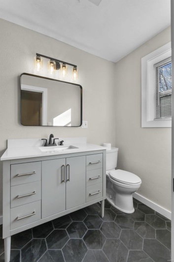 Bathroom featuring baseboards, vanity, and toilet