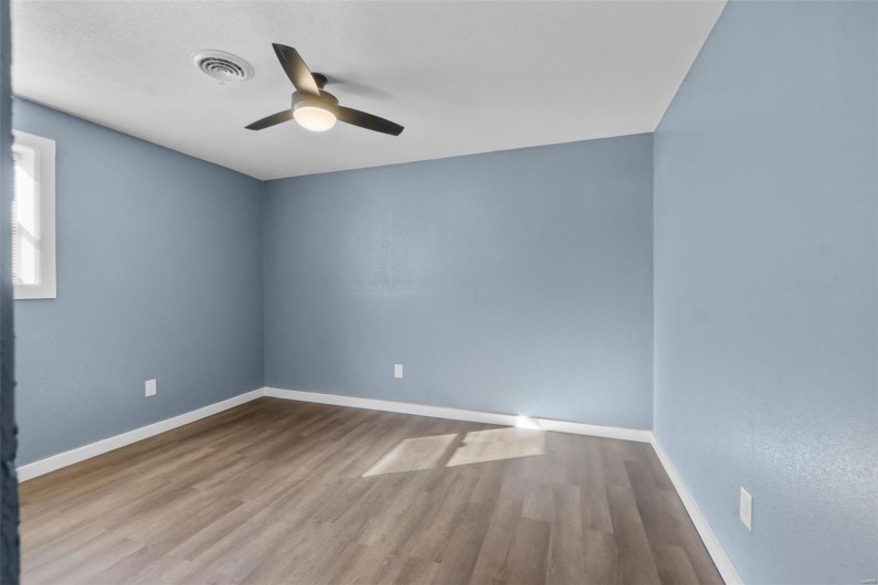 Spare room featuring ceiling fan, wood finished floors, visible vents, and baseboards