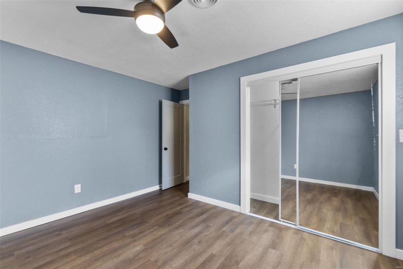 Unfurnished bedroom with ceiling fan, a closet, wood finished floors, and baseboards
