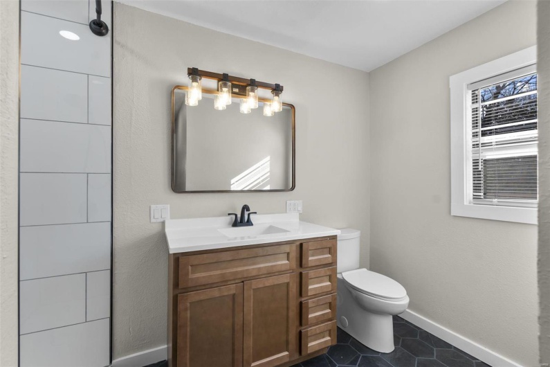 Bathroom featuring vanity, tile patterned flooring, toilet, and baseboards