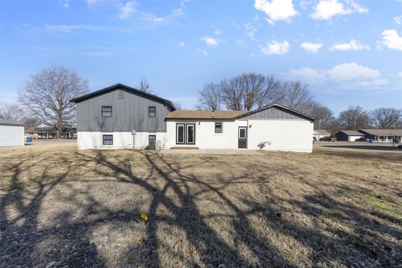 Back of house featuring a lawn and a patio