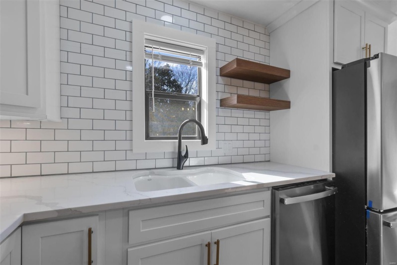 Kitchen featuring a sink, white cabinets, appliances with stainless steel finishes, backsplash, and open shelves