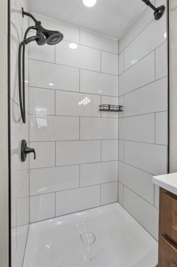 Bathroom with tiled shower and vanity