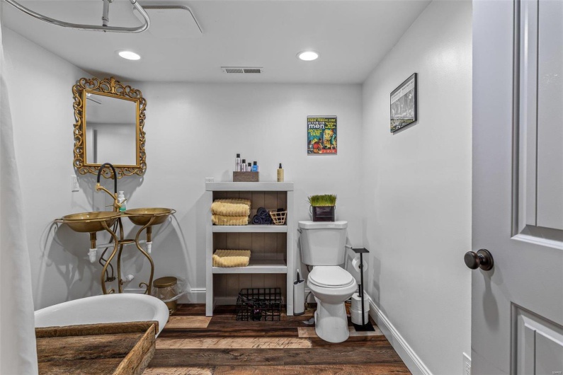 Bathroom with baseboards, visible vents, toilet, and wood finished floors