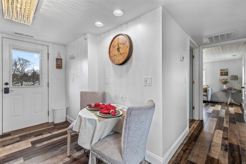 Dining space with wood finished floors, visible vents, and baseboards
